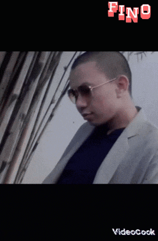 a man with a shaved head wearing sunglasses and a video cook watermark