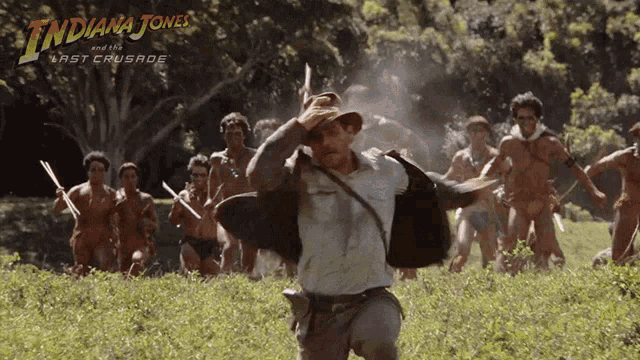 a poster for indiana jones and the last crusade shows a man running in a field