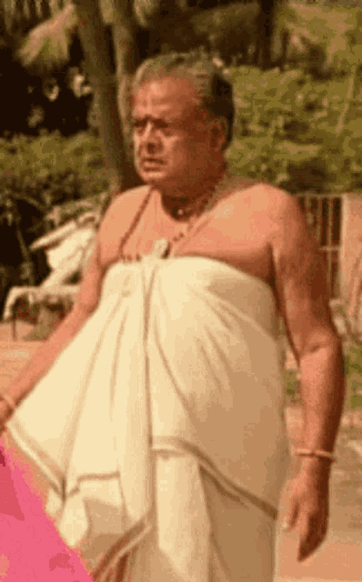 a man without a shirt is wearing a white cloth around his waist .