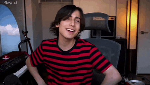 a man in a red and black striped shirt is smiling