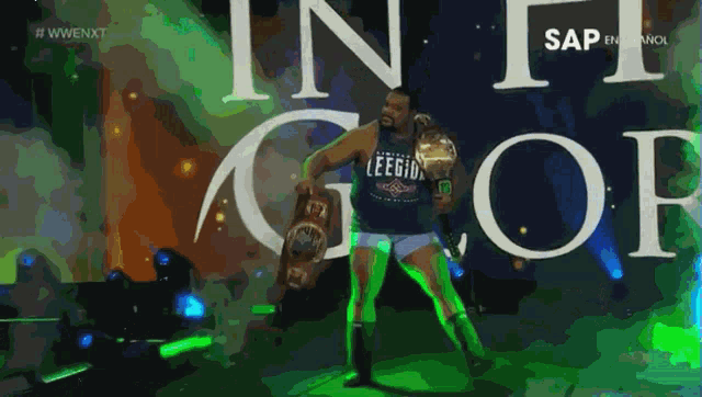 a man wearing a leegid shirt is holding a championship belt