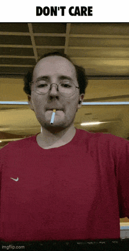 a man wearing glasses and a red shirt smoking a cigarette with the words " do n't care " above him