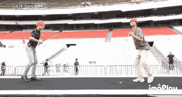 two men are dancing in an empty stadium with a caption that says ' imgplay '