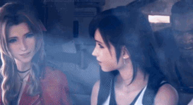 two women are sitting next to each other in a dark room .