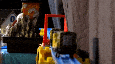 a toy train is going down a track in a room .