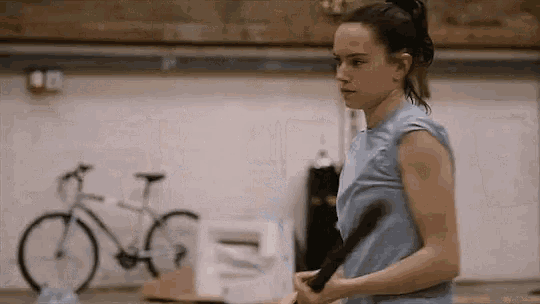 a young woman is holding a tennis racquet in a gym .