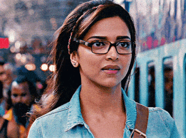 a woman wearing glasses and a denim shirt