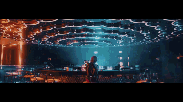 a woman stands in front of a bar in a night club
