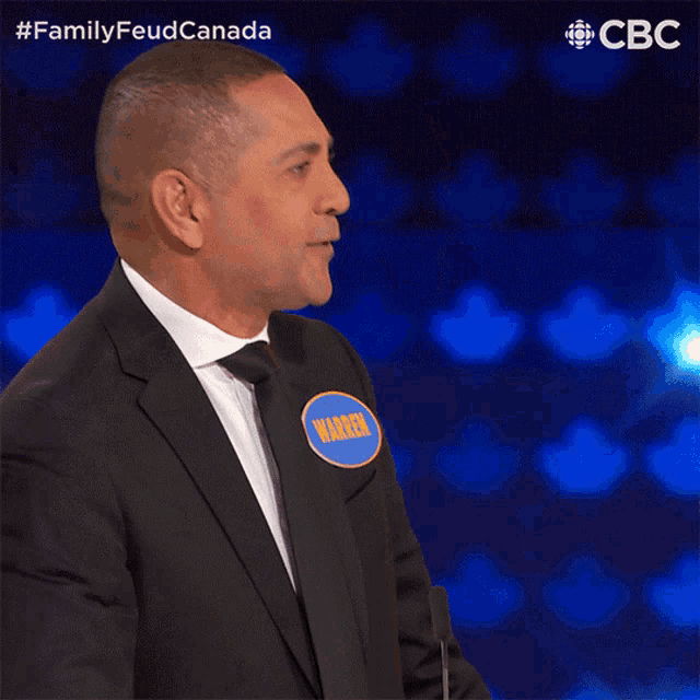 a man in a suit and tie with the name warren on his name tag