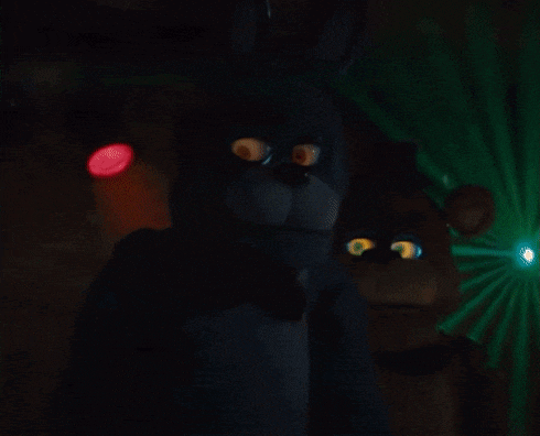 a stuffed bunny rabbit is standing in a dark room with a red light in the background .
