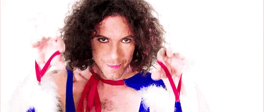 a man with curly hair is wearing a blue and white outfit with a red ribbon around his neck