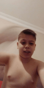 a shirtless boy taking a selfie with his hand in the air