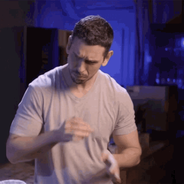 a man in a grey shirt is wrapping his hands in white tape