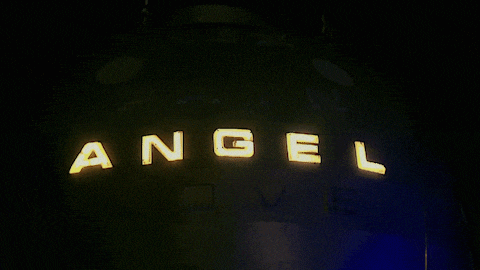 a sign that says angel on it in the dark