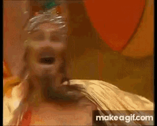 a close up of a person 's face with their mouth open and a balloon in the background .