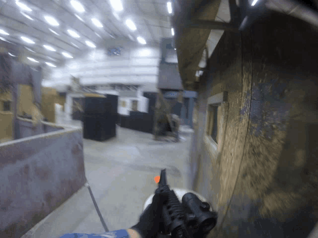 a blurry picture of a person holding a gun in a building