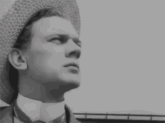 a black and white photo of a man wearing a straw hat and bow tie