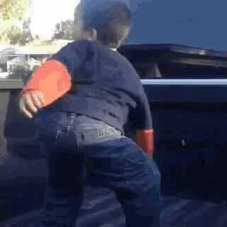 a young boy is standing in the back of a car