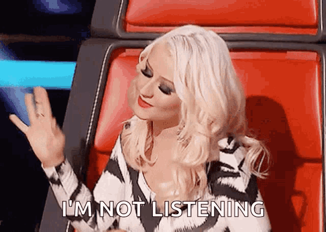 a woman sitting in a chair with the words " i 'm not listening " on the bottom