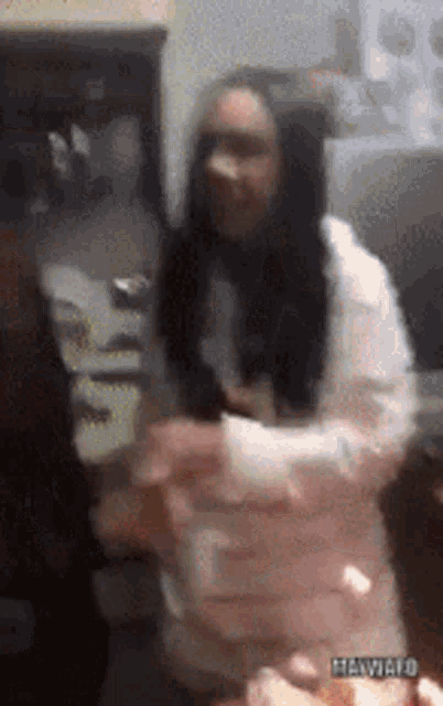 a woman in a white shirt is dancing in a room with a watermark that says hewiaro
