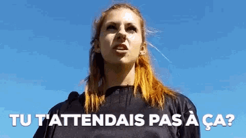 a woman with red hair stands in front of a blue sky with the words tu t'attendais pas a ca