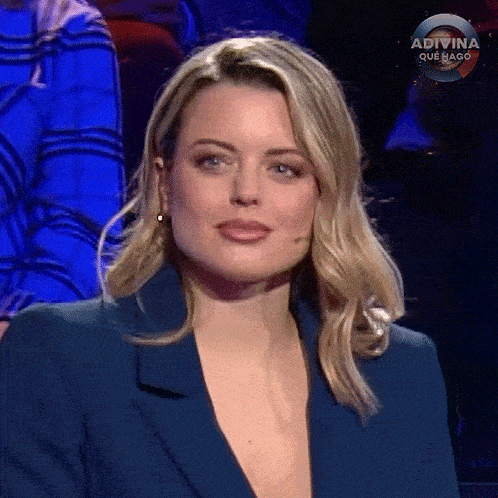 a woman in a blue jacket is sitting on a stage .