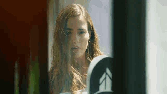 a woman is looking at herself in a mirror with an arrow pointing to the left