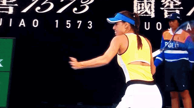 a woman is playing tennis in front of a sign that says 1573