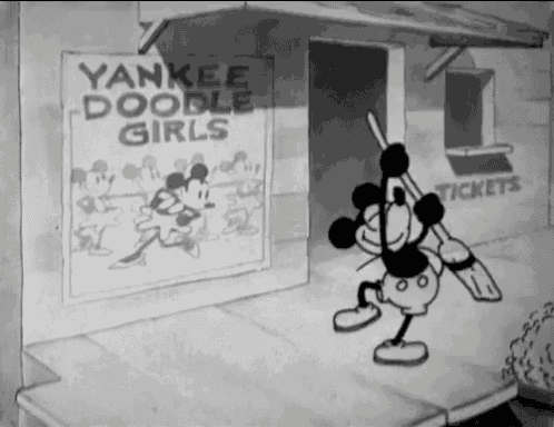 mickey mouse is standing in front of a yankees doodle girls sign