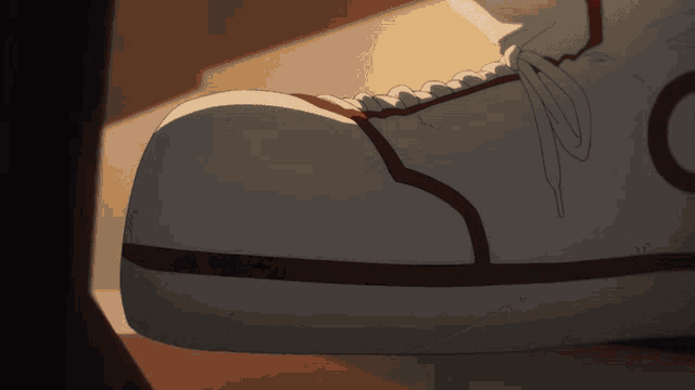 a close up of a person 's shoe with a red stripe on the side