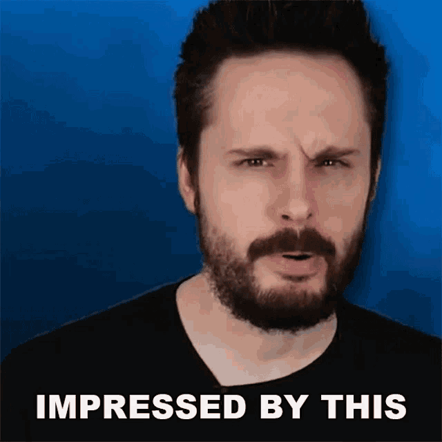 a man with a beard is making a funny face with the words impressed by this below him