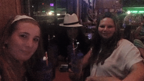 a woman in a white hat sits at a table with two other people