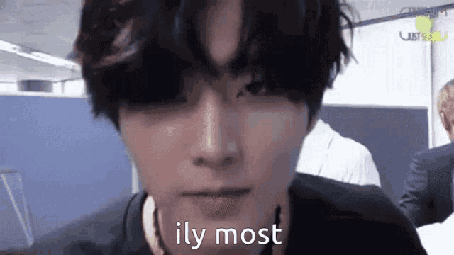 a close up of a young man 's face with the words `` ily most '' written on it .