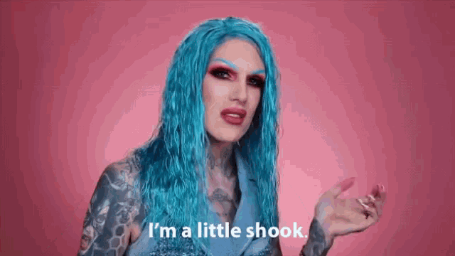 a woman with blue hair and tattooed arms is saying `` i 'm a little shook '' .
