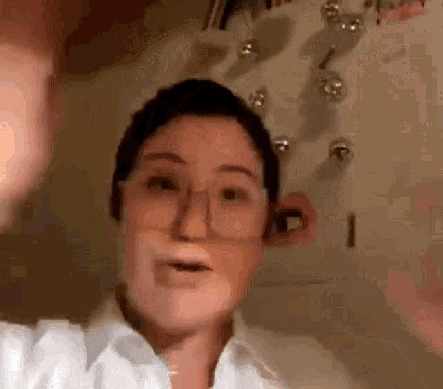 a woman wearing glasses and a white shirt is making a face .