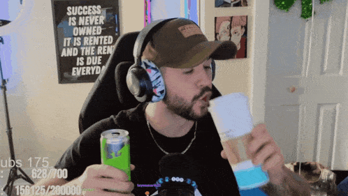 a man wearing headphones and a hat is holding a cup of coffee