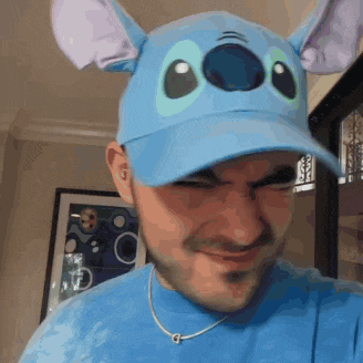 a man wearing a stitch hat and a blue shirt