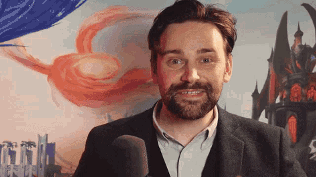 a man with a beard is standing in front of a microphone