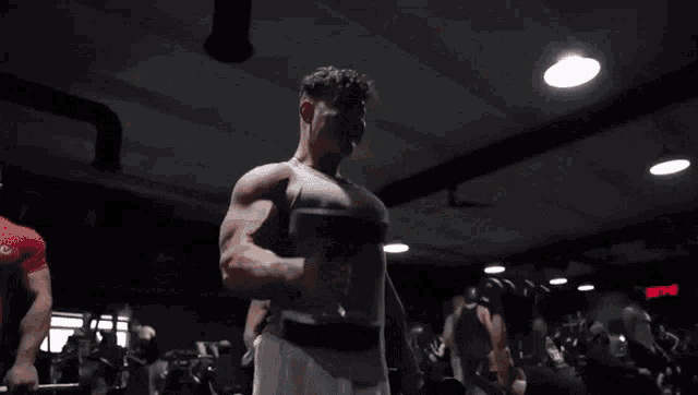 a man is lifting dumbbells in a gym with a sign that says ' action '