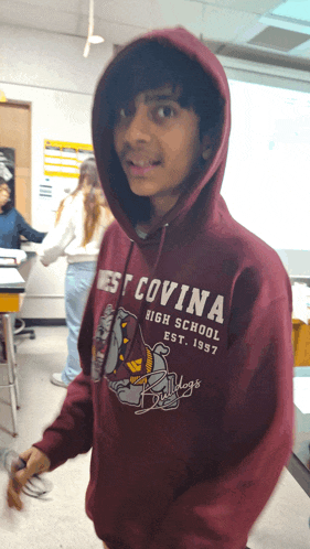 a boy wearing a hoodie that says west covina high school est 1937