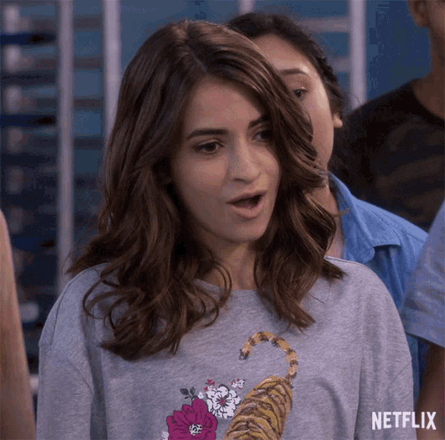 a woman with a surprised look on her face wears a netflix t-shirt