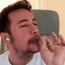 a man with a beard is wearing ear buds
