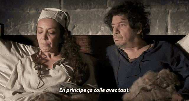 a man and a woman are laying in bed and the woman is saying " en principe ca colle avec tout "