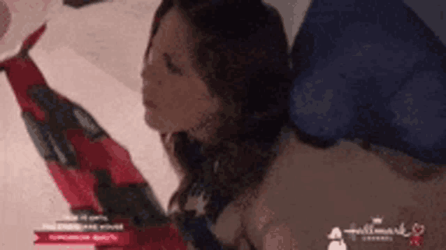 a woman is laying on a bed with a hallmark logo on the bottom