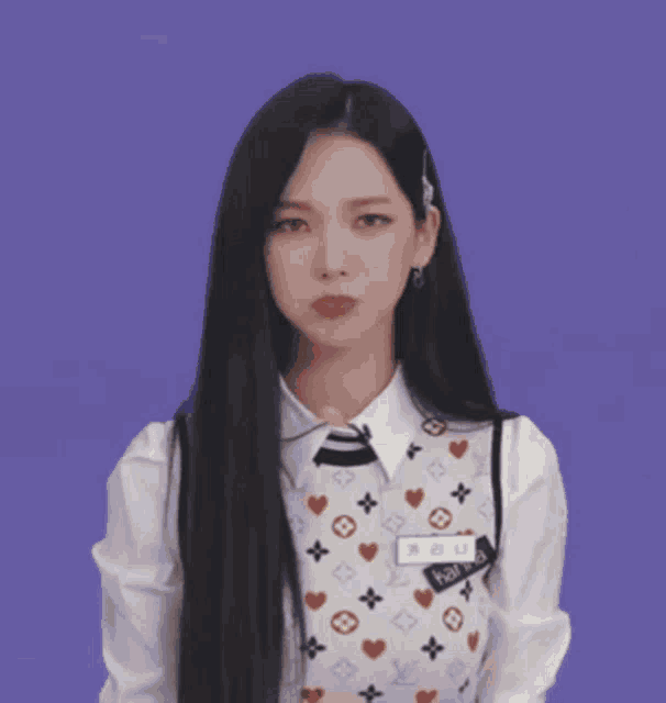 a woman with long black hair is standing in front of a yellow smiley face that says hello