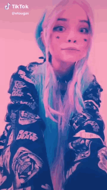 a girl with purple hair and a black shirt with star wars on the sleeves