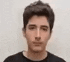 a close up of a young man 's face with a blurred background .
