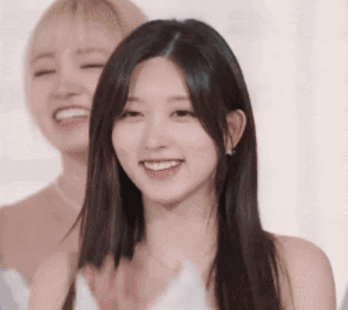 a woman with long hair is smiling and clapping