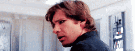 a close up of a man 's face with a surprised look on his face in a room .