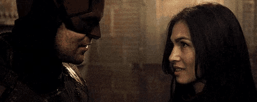 a man in a mask and a woman are looking at each other and smiling .